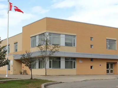 Canadian flag waves outside the front of a school